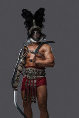 Studio shot of isolated on gray background gladiator swordsman wielding twin swords.