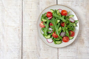 Spring vegan salad with spinach, cherry tomatoes, corn salad, baby spinach and cucumber. Healthy food concept. wooden table. Top view. Copy space
