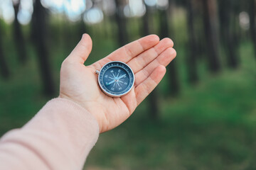 Compass in the hand on the nature background.