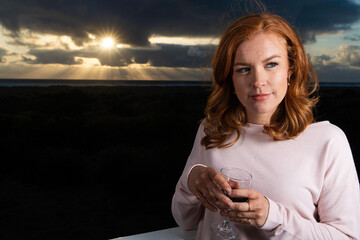 Pretty woman with red hair and freckles at the ocean beach