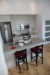 Appartement kitchen in a modern loft with stainless fridge and oven and microwave and table for breakfast