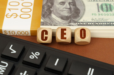 On the table are dollars, a calculator and cubes with the inscription - CEO