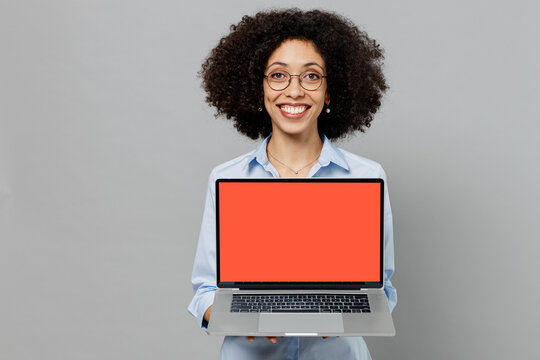 Young fun employee business corporate lawyer woman of African American ethnicity in formal shirt at office hold use work on laptop pc computer blank screen workspace area isolated on grey background.