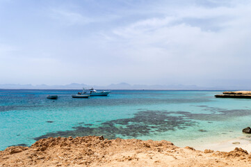 Fototapeta na wymiar Paradise beach coastline. Beauty of Egypt nature. Red Sea seascape with corals and boats.