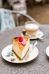 Big piece of delicious cheesecake and cappuccino on an outdoor table at a café