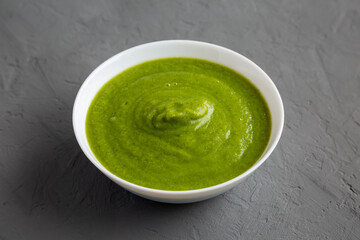 Homemade Organic Broccoli Soup on gray background, side view.