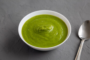 Homemade Organic Broccoli Soup on gray background, side view.