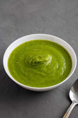 Homemade Organic Broccoli Soup on gray surface, side view.