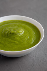Homemade Organic Broccoli Soup on gray background, low angle view.