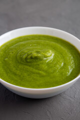 Homemade Organic Broccoli Soup on gray background, side view.