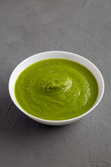Homemade Organic Broccoli Soup on gray surface, side view.