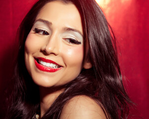 Beautiful Smiling European Brunette Fashion Model with Bright Lighting and Red Background