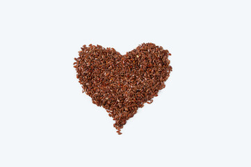 Flax seeds in the shape of heart. White background.