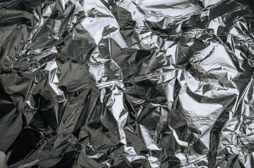 Background, texture of silver shiny foil, colored crumpled wrapping paper. Photo, top view, copy space.