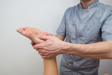Male massage therapist massaging the foot of a young girl