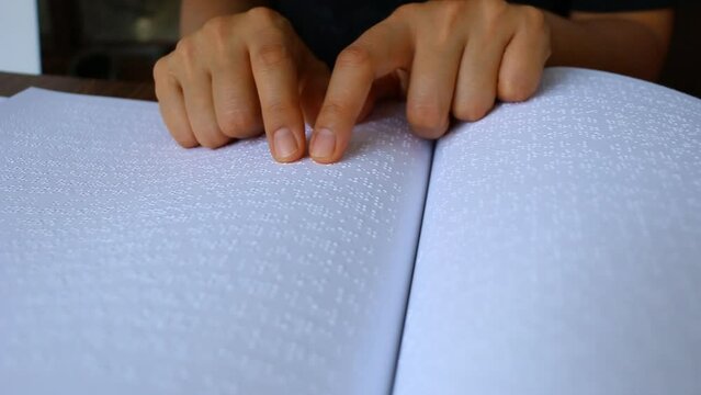 Close up female hand reading braille
