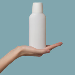 A woman's hand holds a white bottle of shampoo. Template blank copyspace. Blue background.