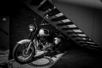 under a staircase is a classic old motorcycle