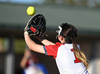 Athletic girls in action playing in a softball game