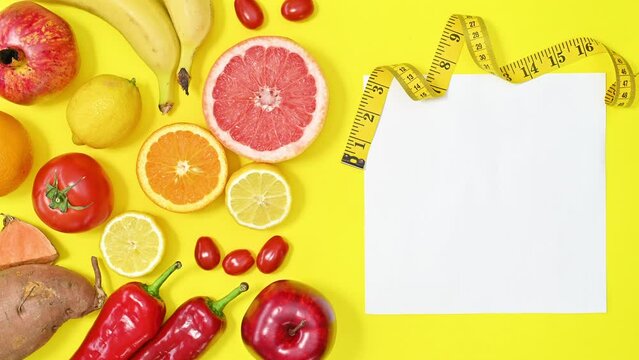 Creative copy space on yellow background with red fruits and vegetables. Diet and healthy food concept. Stop motion flat lay