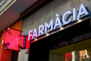 Pharmacy in Spanish for news. Red led cross, symbol of health, medicine, self-care. Farmacia sign...