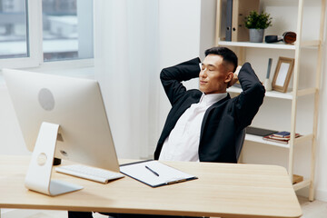 man in a suit sits at a table in front of a computer Lifestyle