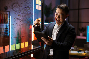 Brainstorming, success concept. Happy excited Asian businessman, holding tablet computer and...