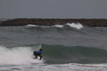 Biarritz coast beach with lighthouse and surfers