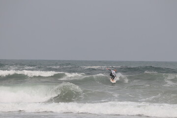 Biarritz coast beach with lighthouse and surfers