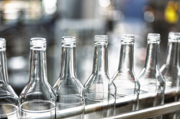 Production line transports empty glass bottles for alcohol