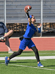 Young boy throwing and running with the ball during a flag football game