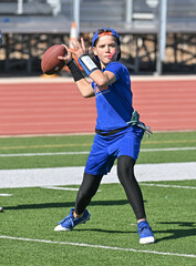 Young boy throwing and running with the ball during a flag football game