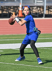 Young boy throwing and running with the ball during a flag football game