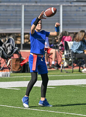 Young boy throwing and running with the ball during a flag football game