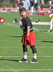 Young athletic boy catching, running and throwing the ball in a football game