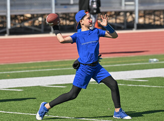 Young boy throwing and running with the ball during a flag football game © Joe