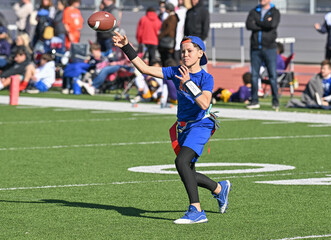 Young boy throwing and running with the ball during a flag football game