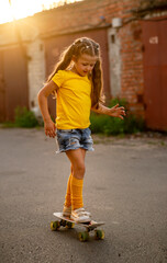 small girl is riding a skateboard © Olena