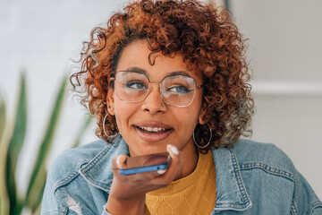 girl with mobile phone sending or recording voice message