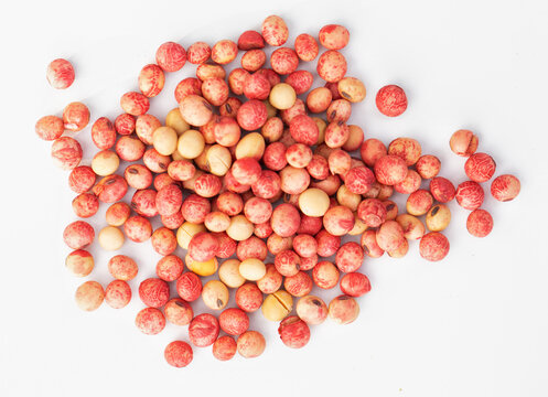 Soybean seeds treated with protective drugs on a white background.