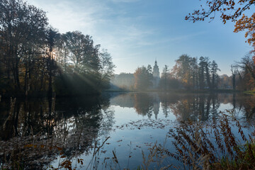 On the banks of the pond in the park, fall colors of the leaves.
