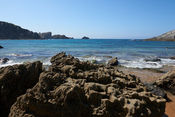 Fototapeta na wymiar Cliffs next to a turquoise blue sea