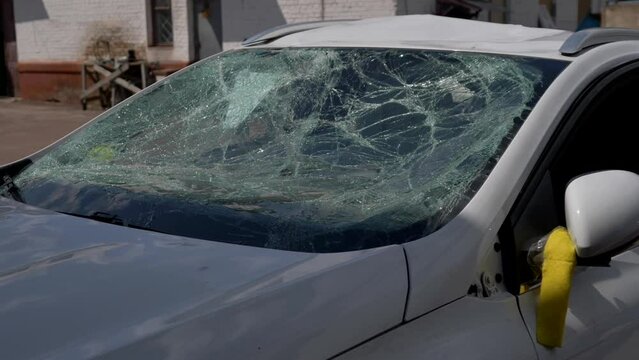 Close-up of a broken windshield in a car after being hit by a pedestrian or a car accident. Damaged car after natural disaster or war. Road safety, car insurance.