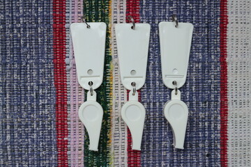 three sports whistle as awards, signal, fan, white with a tag