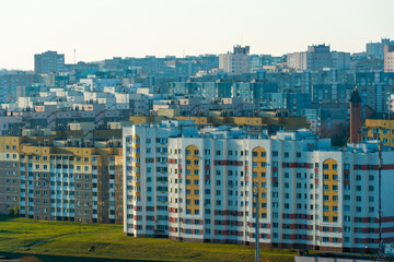 Fototapeta premium Top view of the sleeping area of a big city. Autumn city landscape. Green spaces next to high-rise modern buildings.