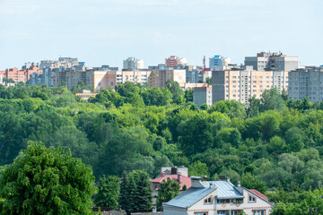 Obraz premium Top view of the sleeping area of a big city. Autumn city landscape. Green spaces next to high-rise modern buildings.