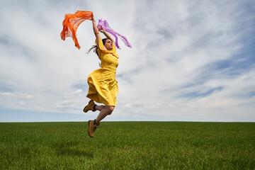 Happy young woman jumping for joy on a wheat field