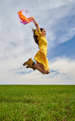 Happy young woman jumping for joy on a wheat field