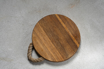 Wooden round tray on a gray background. View from above. Place for text.