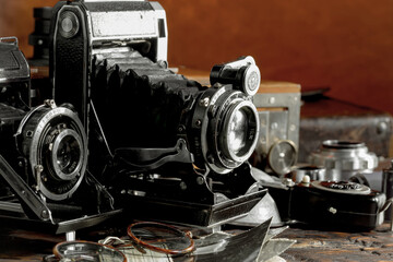 Fototapeta na wymiar Old vintage photo cameras on an old background.